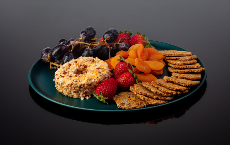 Defrost plate with cheese and fruits on black